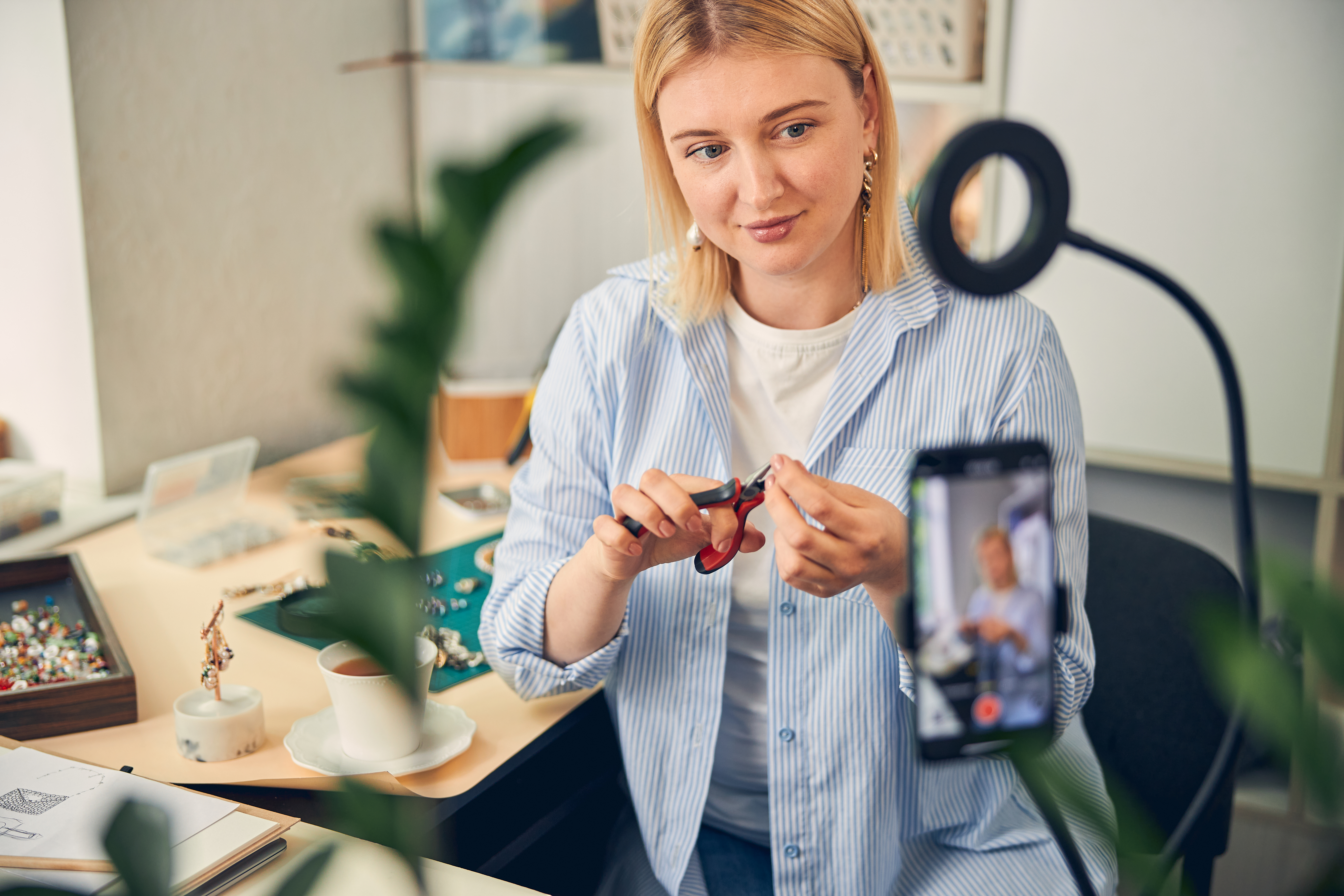 Woman making a video of herself making jewelry