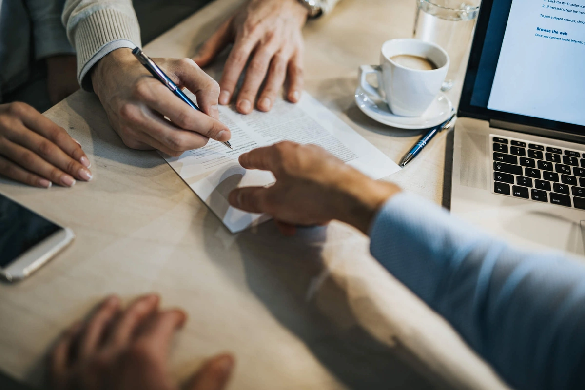 Person signing document at desk