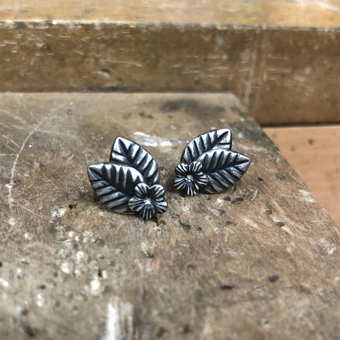 blackened silver studs with two leaves and a flower