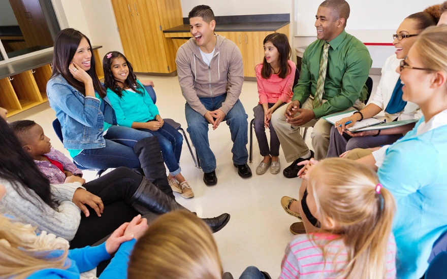 Group of Teachers sitting with students in a circle