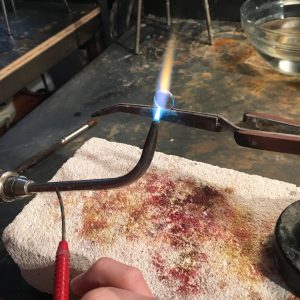 Soldering torch with flame under piece