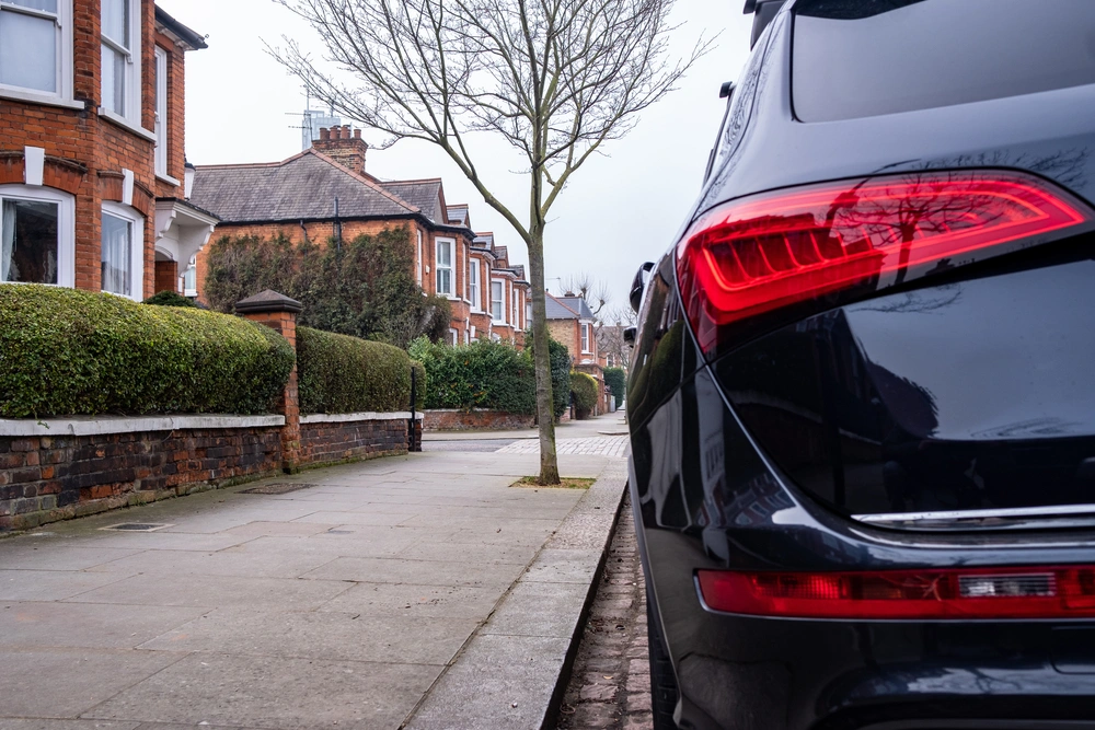 Black car parked up on residential street