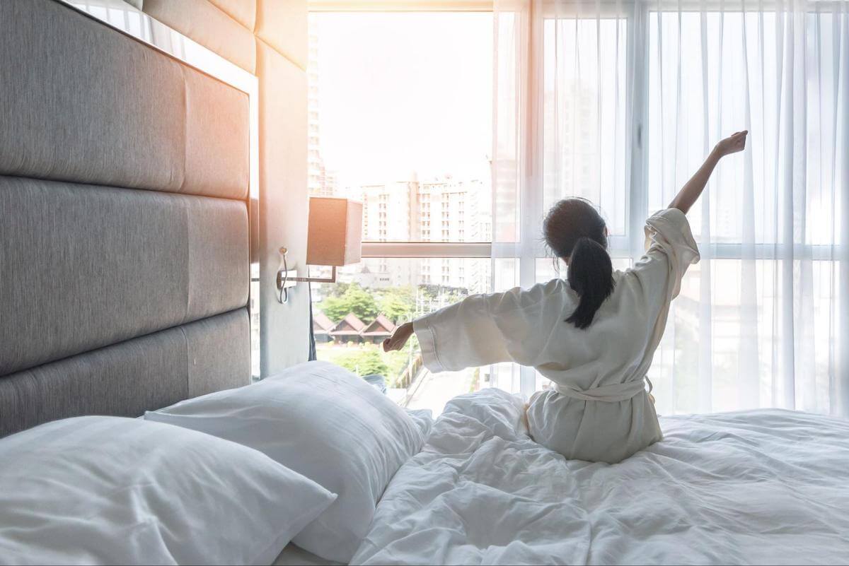 bed shaker alarm clock: Woman stretching while looking out the window