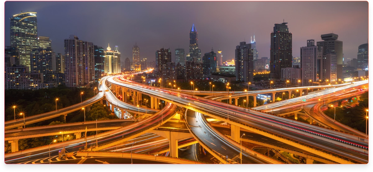 A view of crisscrossing highways with a cityscape of skyscrapers in the background