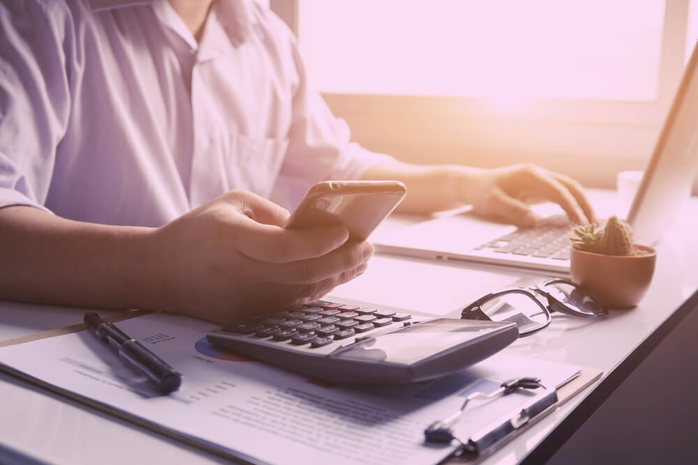Person at laptop with a calculator
