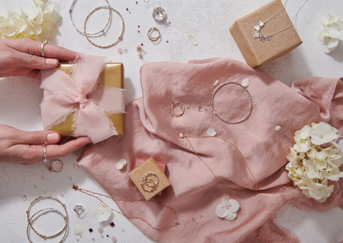 jewelry boxes surrounded by pink fabric, jewelry, and flowers