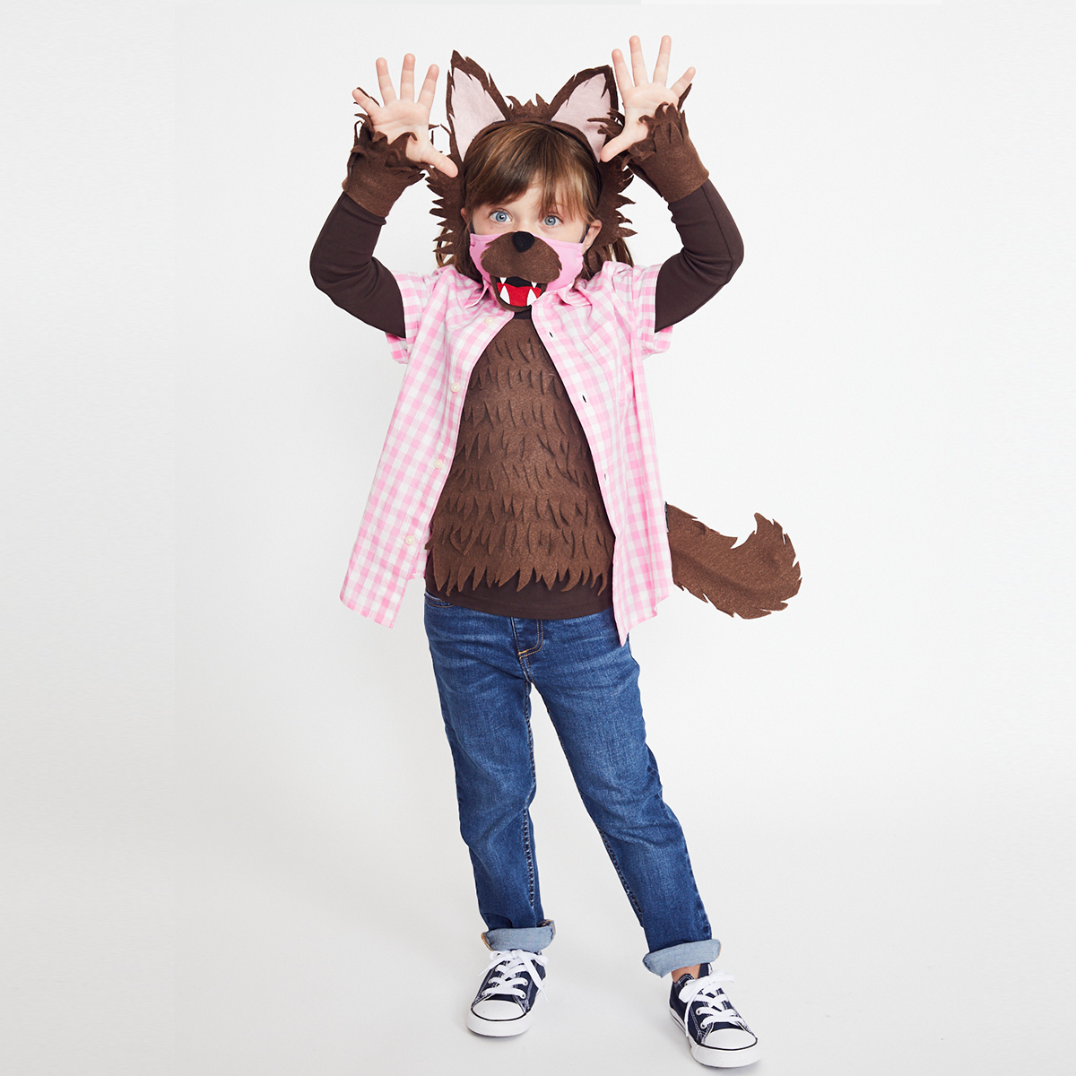 child wear pink gingham shirt over brown werewolf costume with a face mask