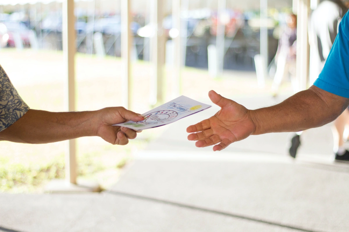 A salesperson hands out a leaflet to a potential offline lead. FiveCRM helps businesses manage both offline and online leads.