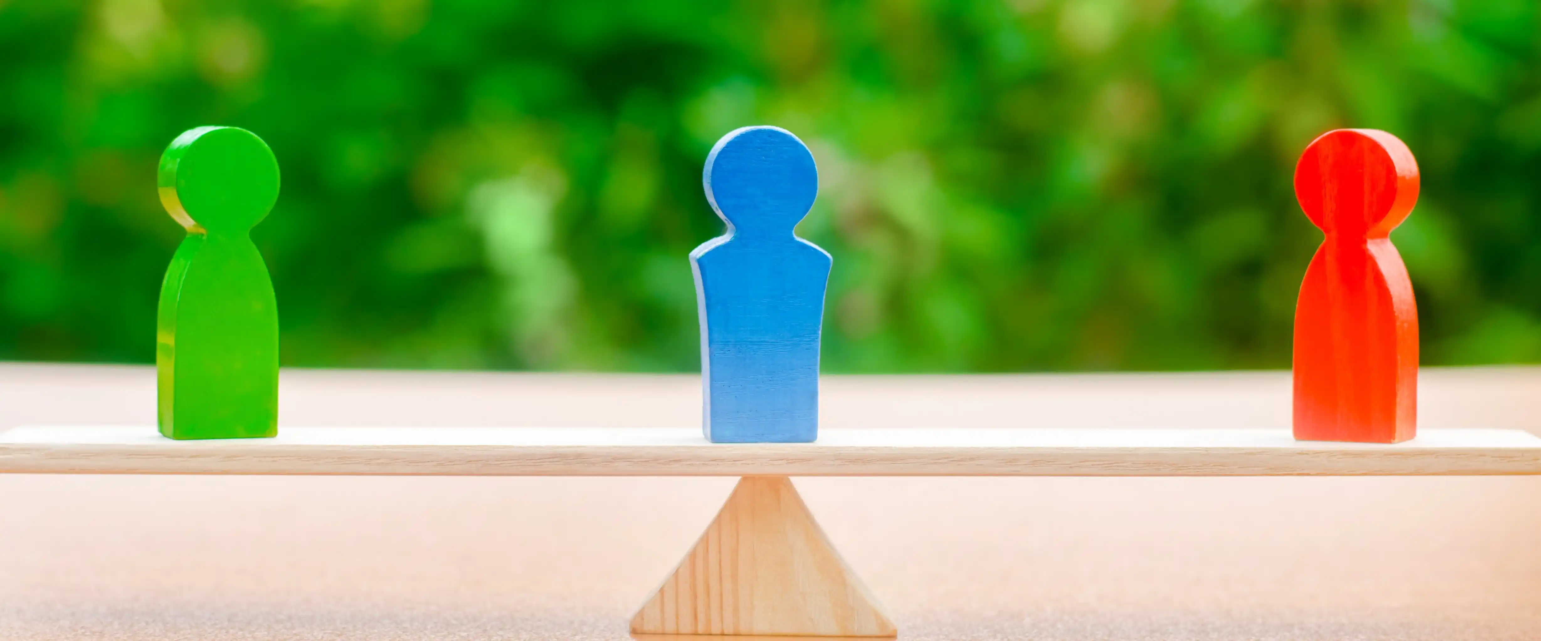 Wooden figures on balance scale representing ethical hiring and CSR fairness