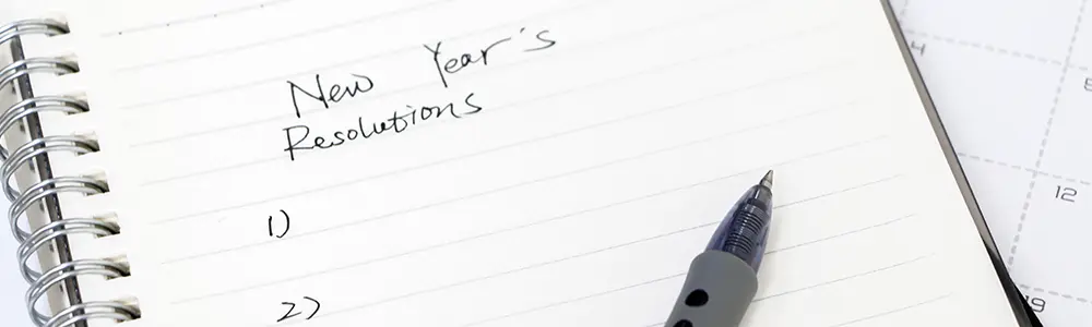 pen and pad of paper with new year's resolution written on it