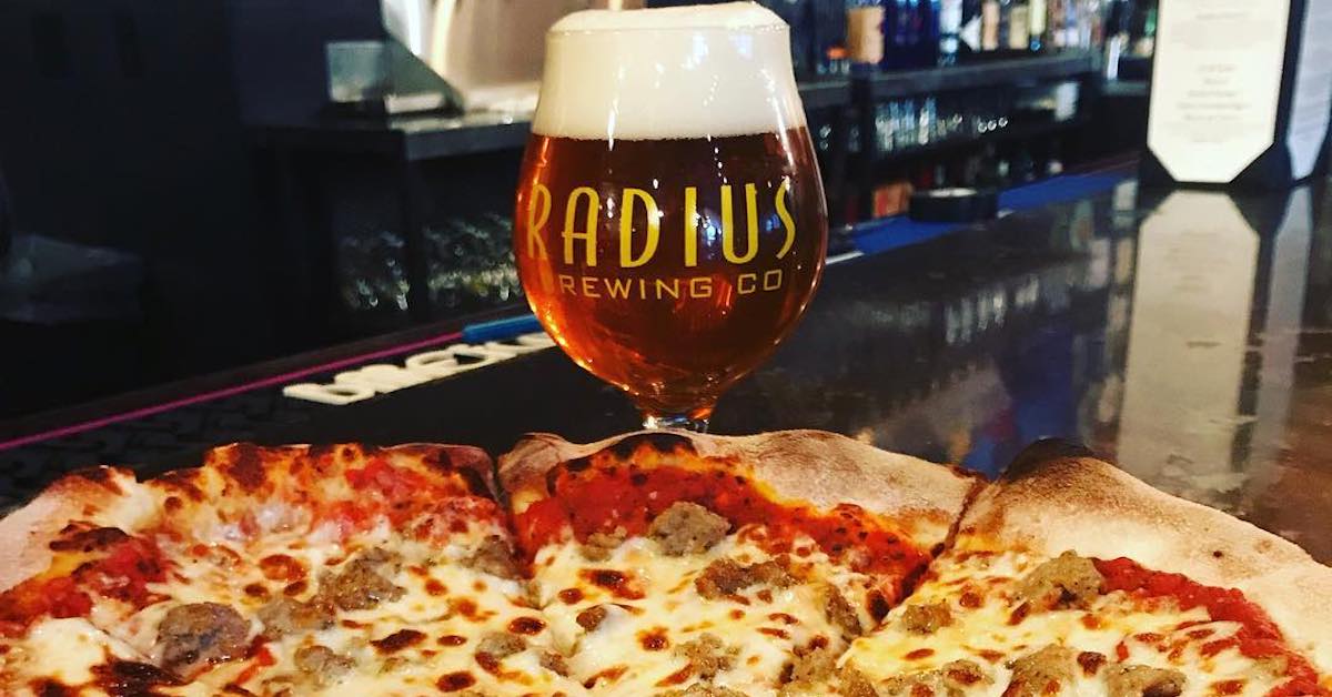 A beer and a sausage pizza