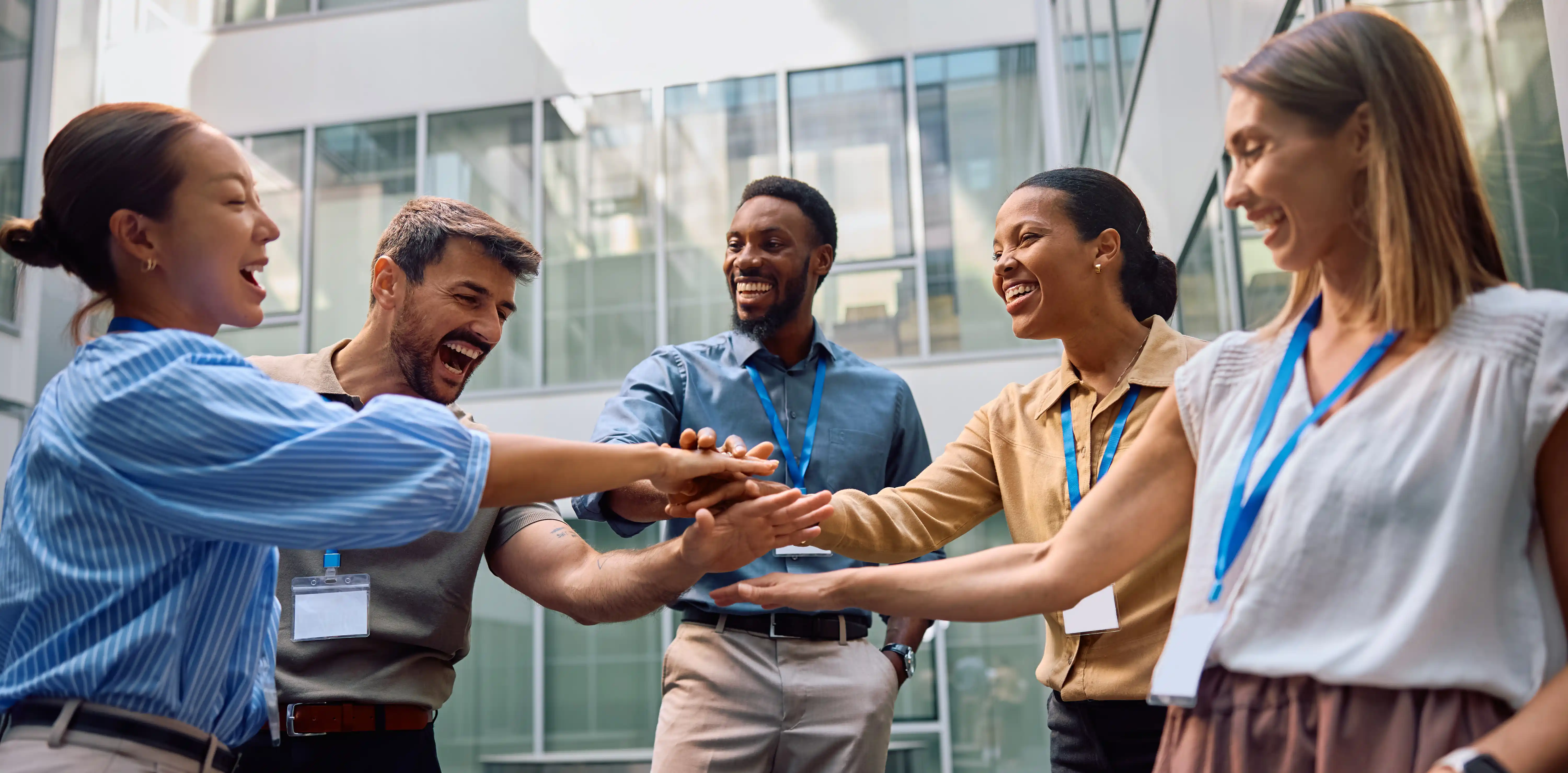 Diverse business team celebrating together representing employee engagement and fair pay benefits model