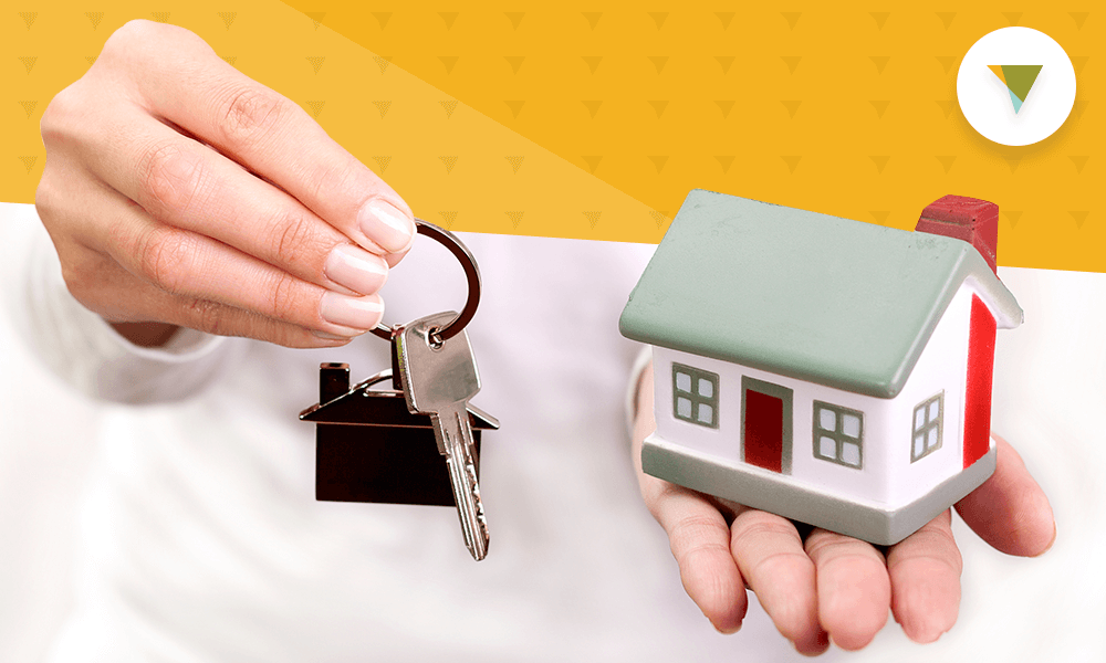 Hand holding toy house and keys