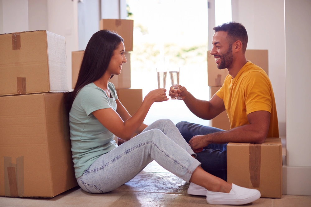 first time buyers toasting to their new home surrounded by boxes