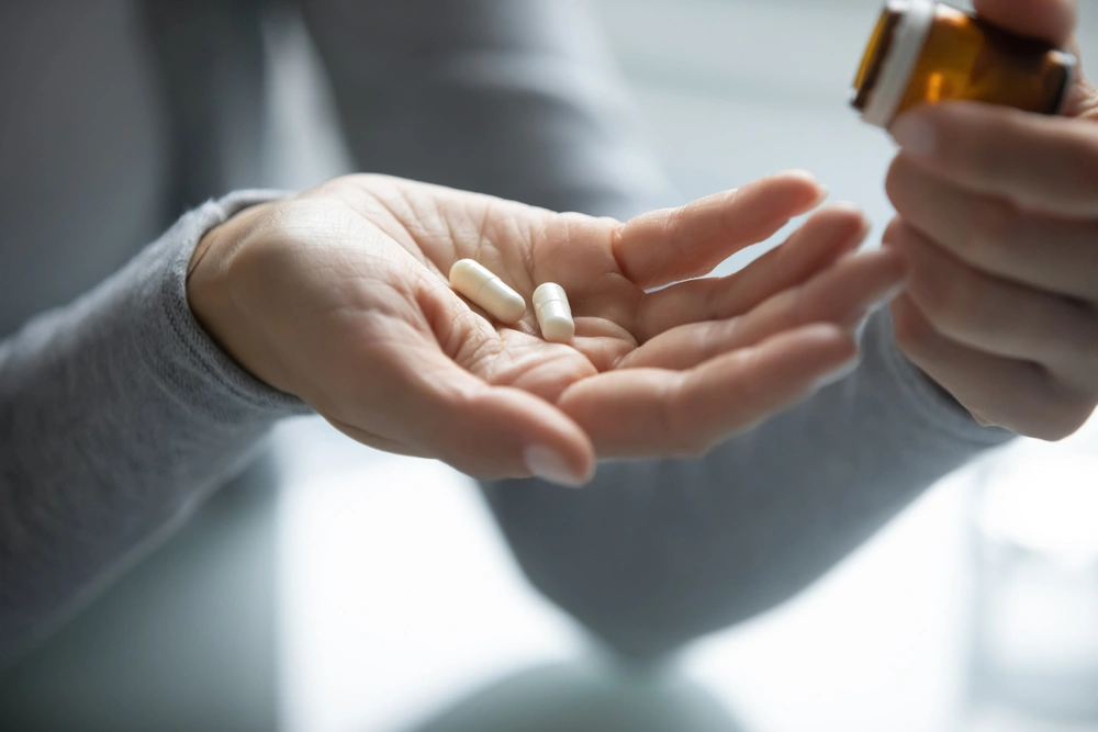 Woman's hand holding a few acne pills