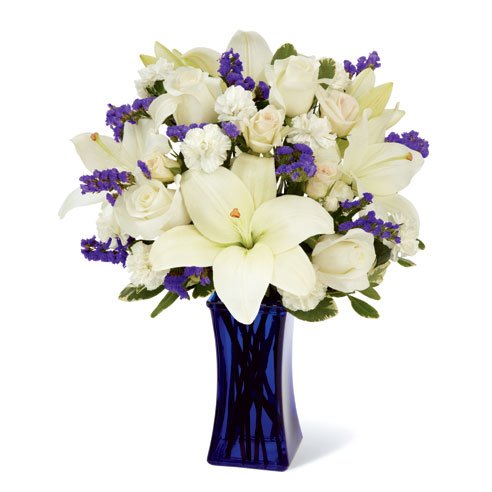 white lily and white rose bouquet in a blue glass vase