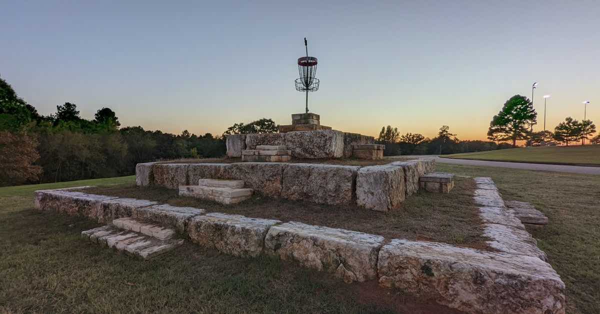 Disc golf basket on tiered rock walls