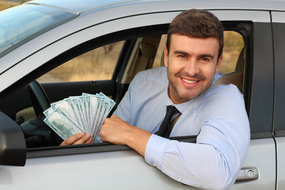 man in car with title loan cash