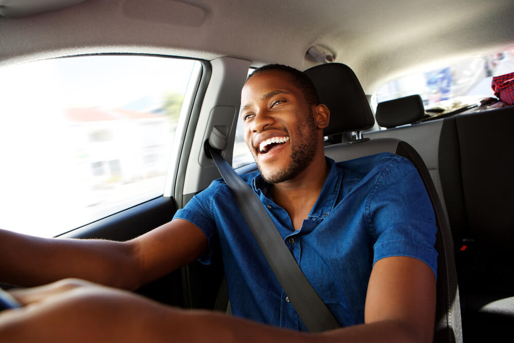 Man in a car happy about auto title loan cash