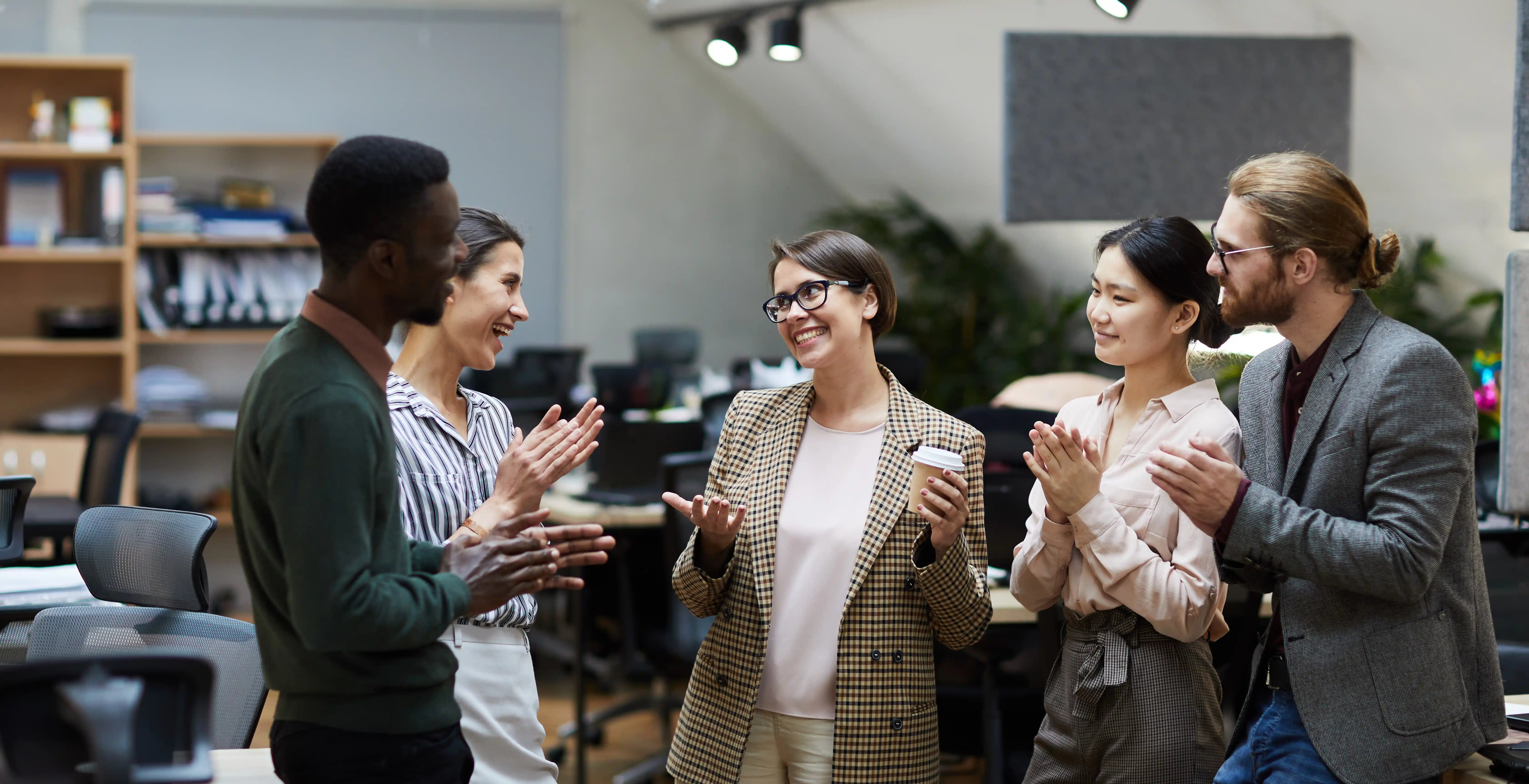 Diverse office team celebrating together representing cultural synchronization