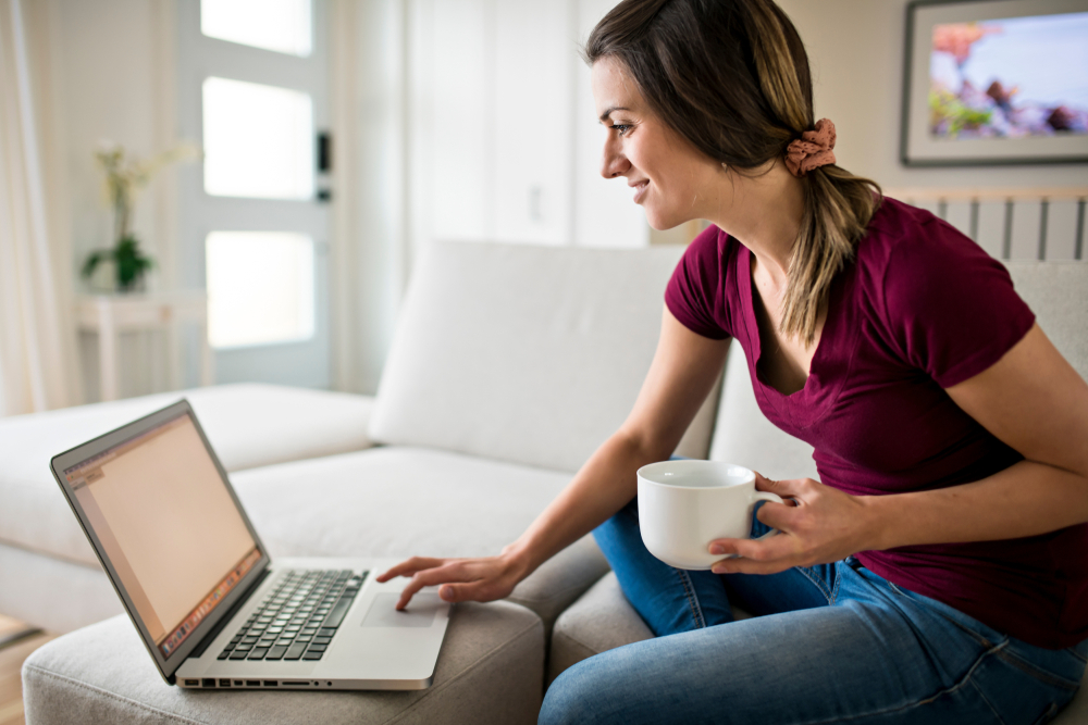 Woman on laptop with cup of coffee