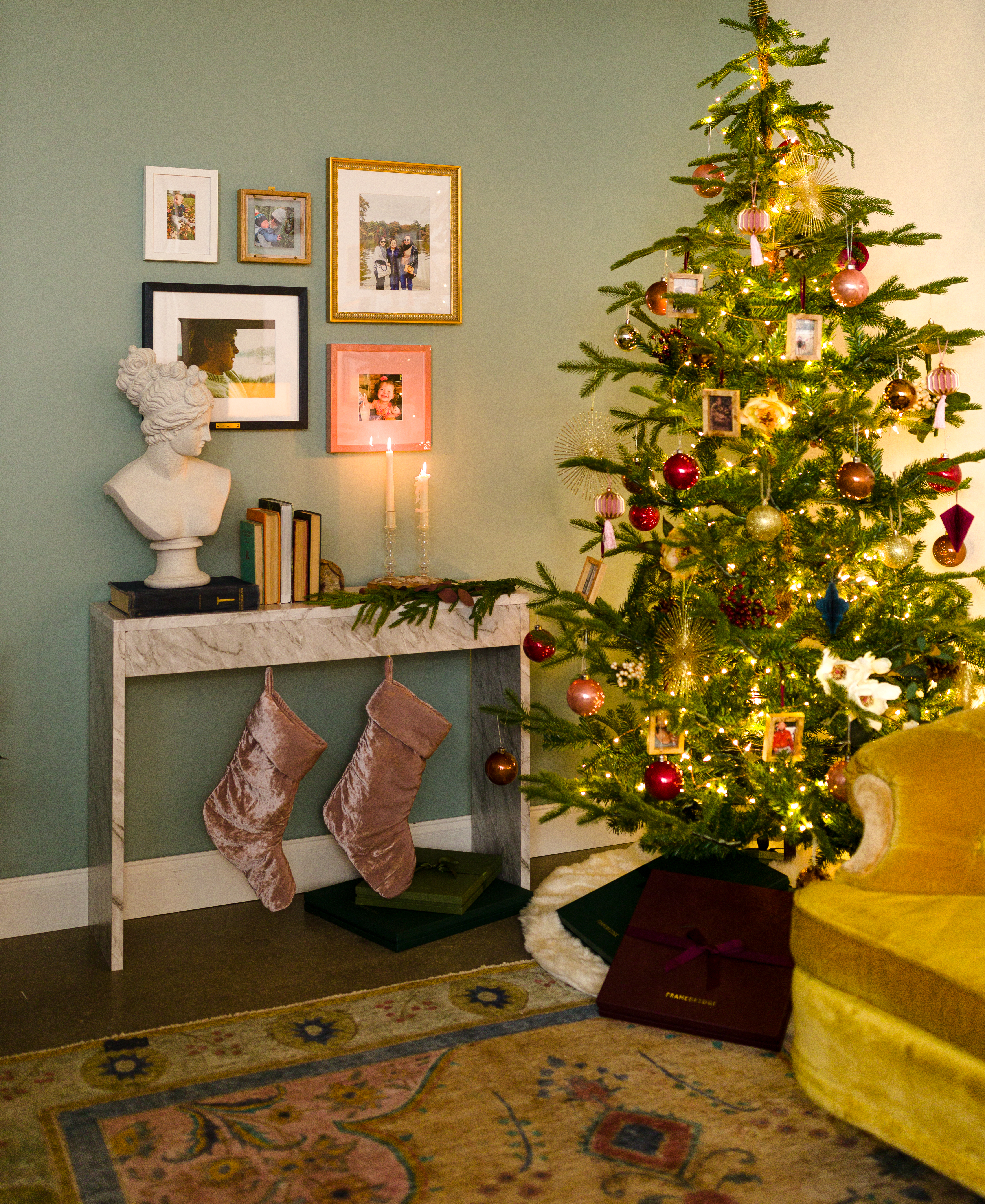 gallery wall over mantle with stocking, next to christmas tree