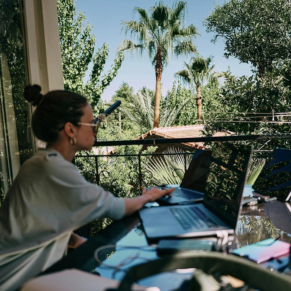 A girl working on the table on the terrace.webp
