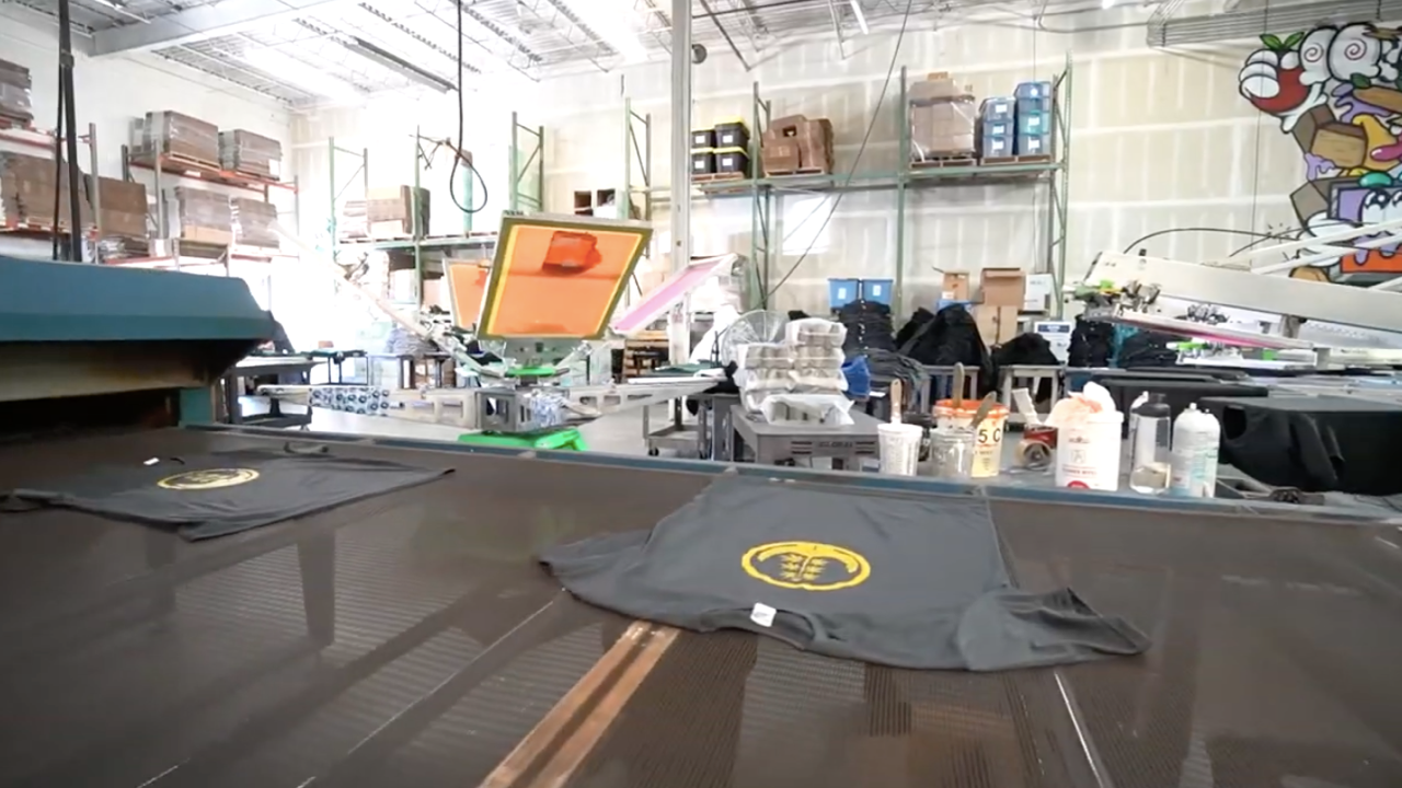 Cannabis merchandise rolling off a screen printing production line (t-shirts)