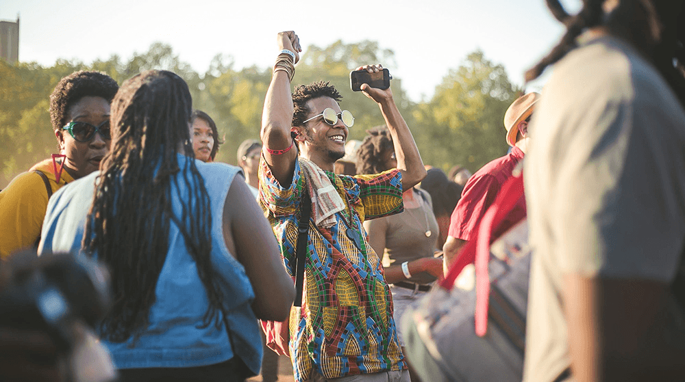 Man in park celebrating with phone