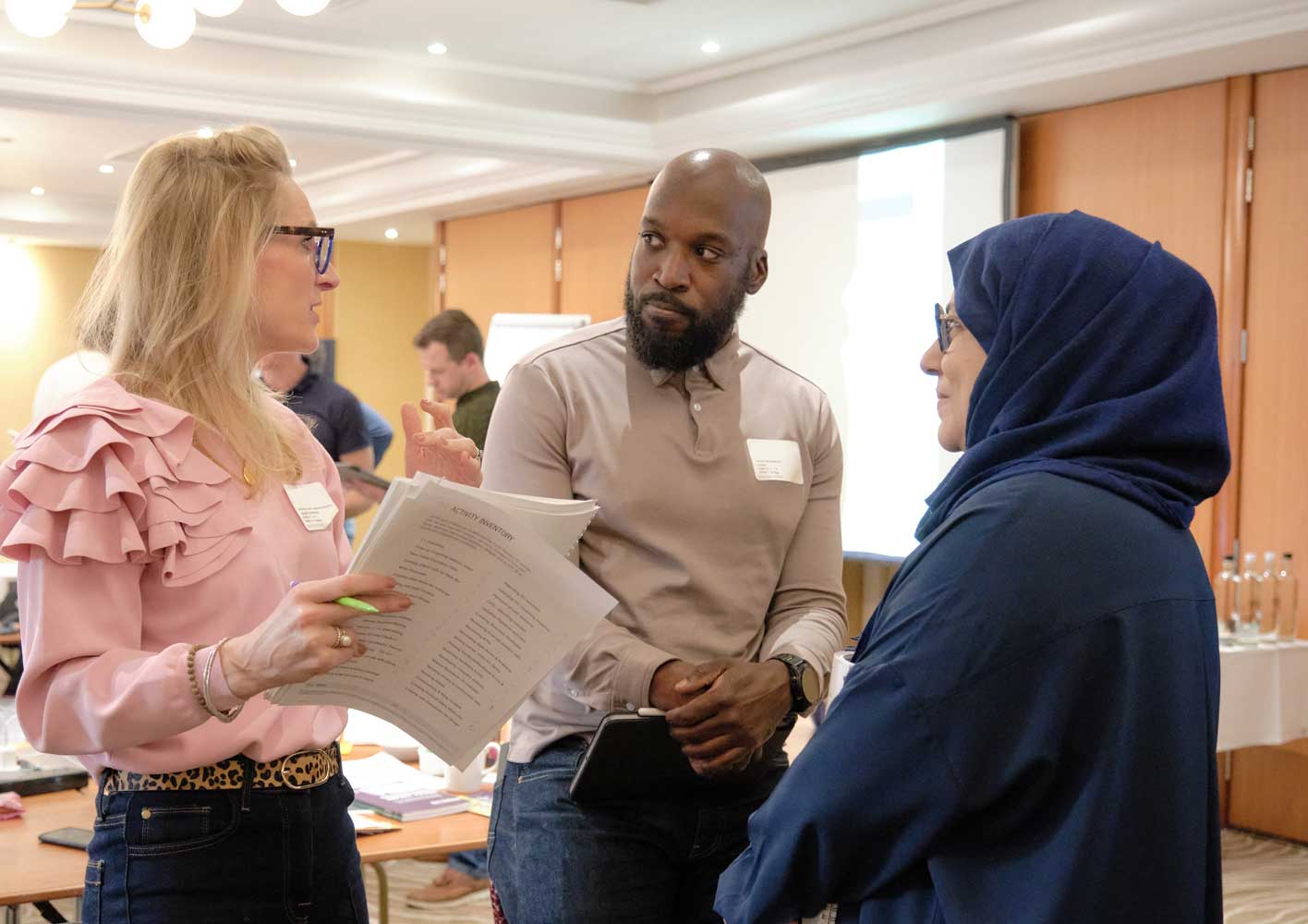 Three Strategic Coach participants talking in workshop for entrepreneurs 