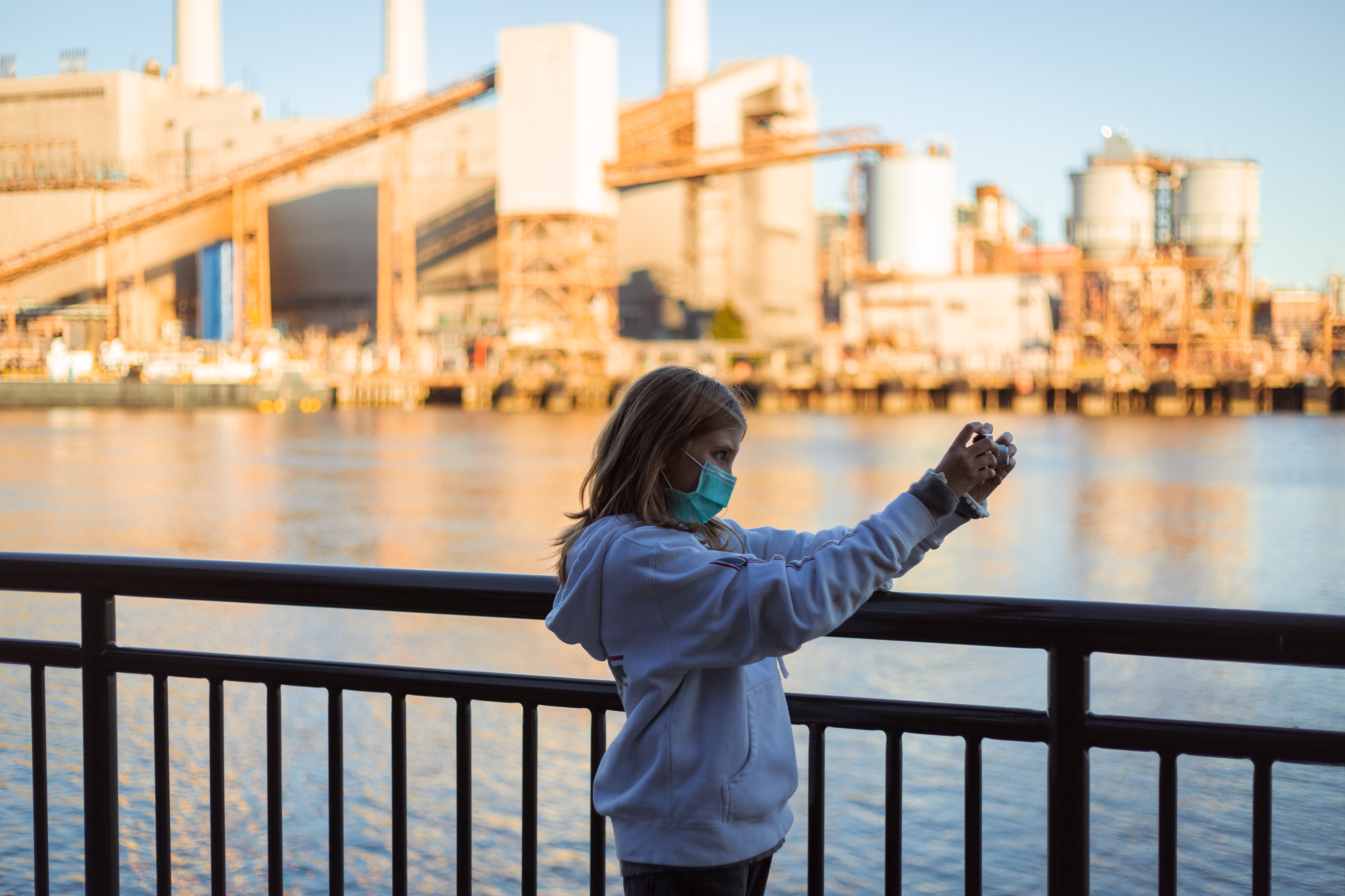 girl taking photo in front of river backdrop