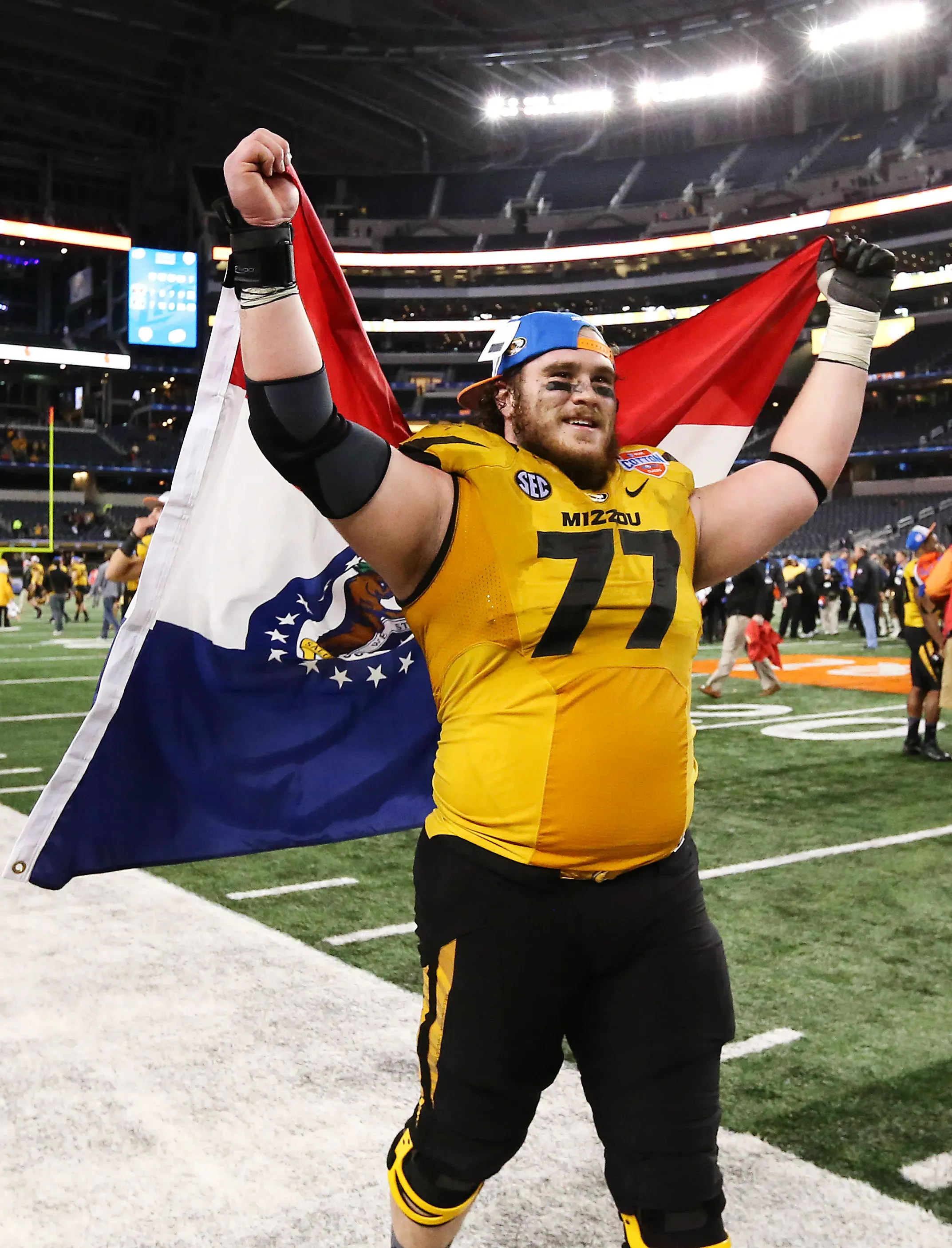 Missouri Tigers offensive linesman Evan Boehm (77) celebrates with the state flag of Missouri after the victory against the Oklahoma State Cowboys in the 2014 Cotton Bowl at AT&T Stadium. 