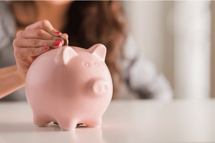 depositing money into piggy bank