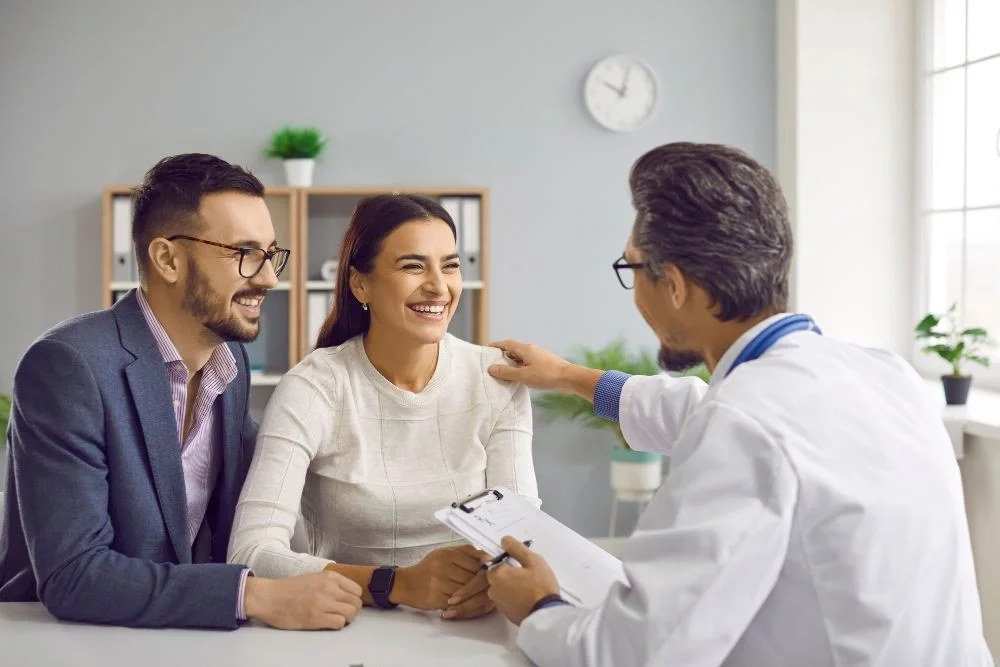 Doctor discussing IUI vs. IVF options with couple during consultation.