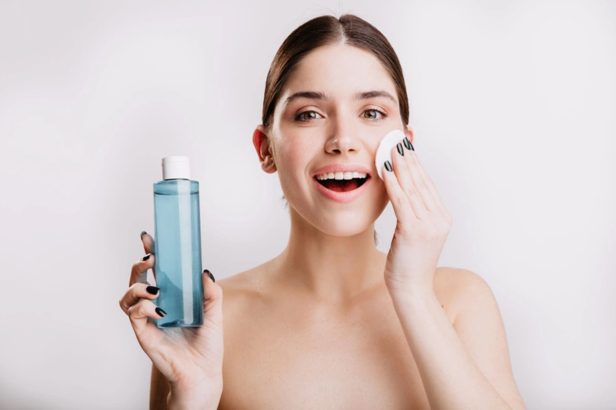 Woman padding her cheeks with micellar water