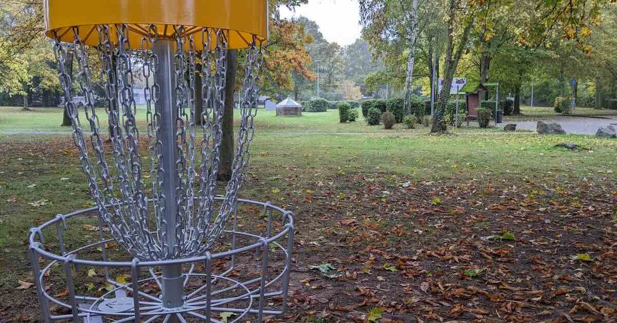 Disc golf basket in park in fall