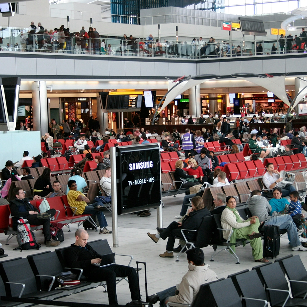 Crowded airport swarming with people.