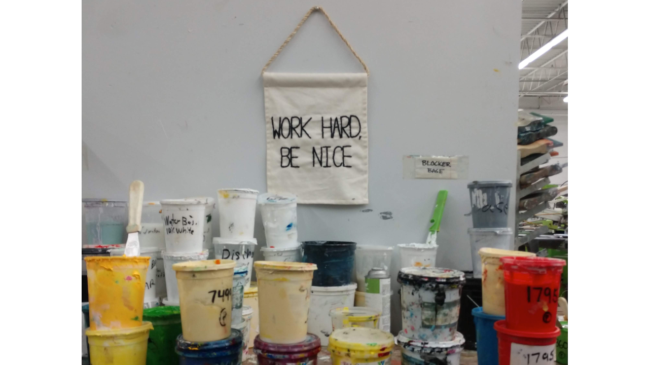 Screen printing inks and a sign telling people to "Work hard and be nice" at Barrel Maker Printing