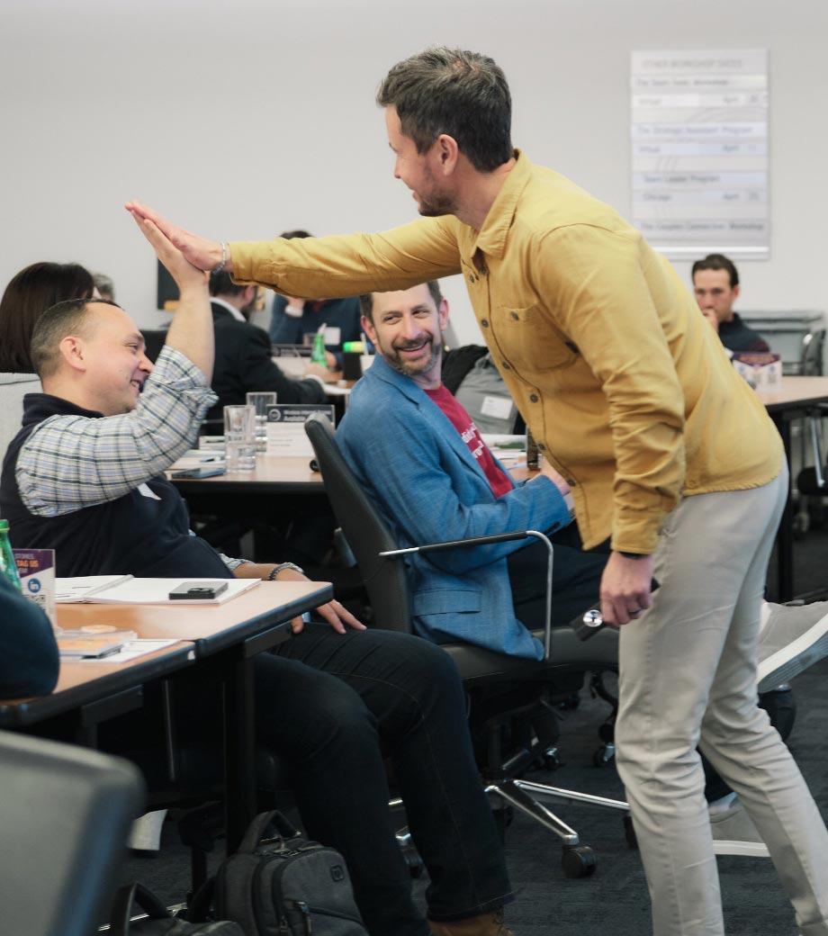 Two Strategic Coach members high fiving in a workshop