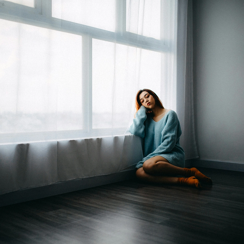 Sad woman sitting on floor.webp