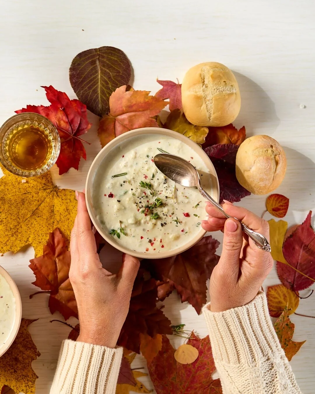 Tomato soup spread with rolls, cookies and fall decorations on a log round plate
