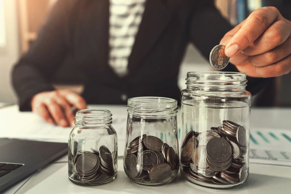 3 savings pots with coins in each one