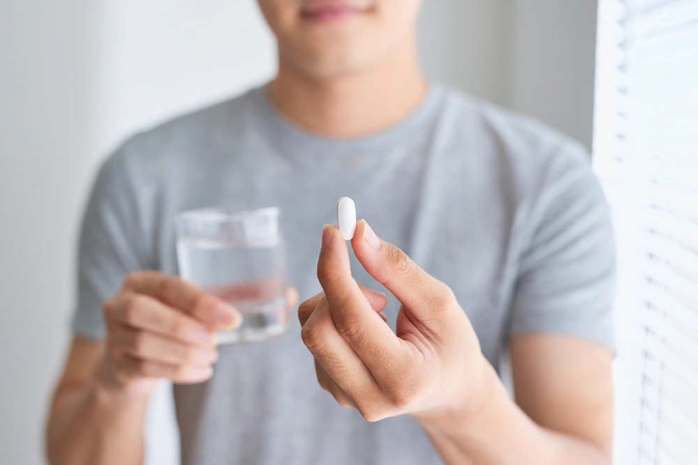 Man looking at a white pill