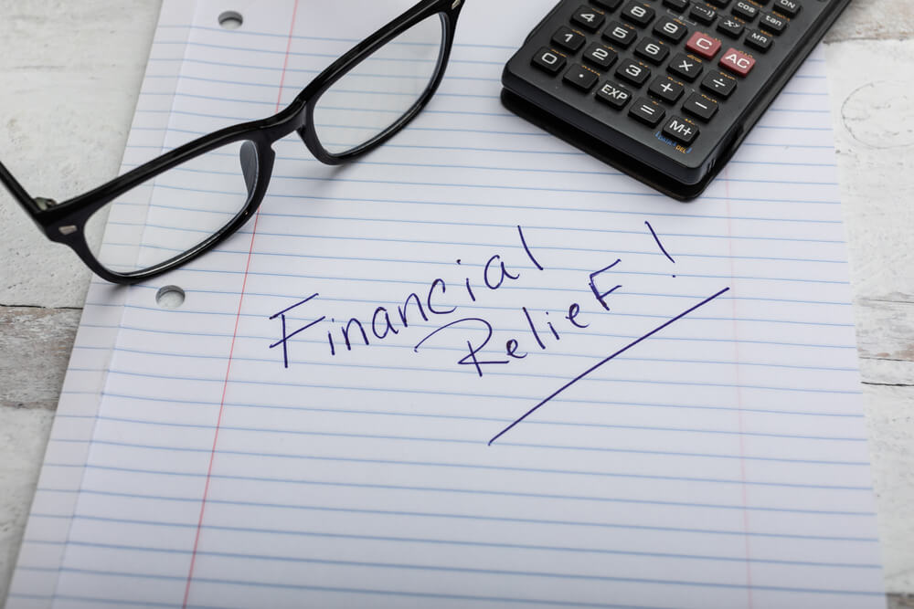 glasses and notepad the says financial relief with car title loan