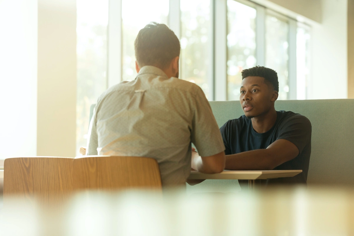 Two men participating in face-to-face customer feedback as part of a critical business process to evaluate the sales process.