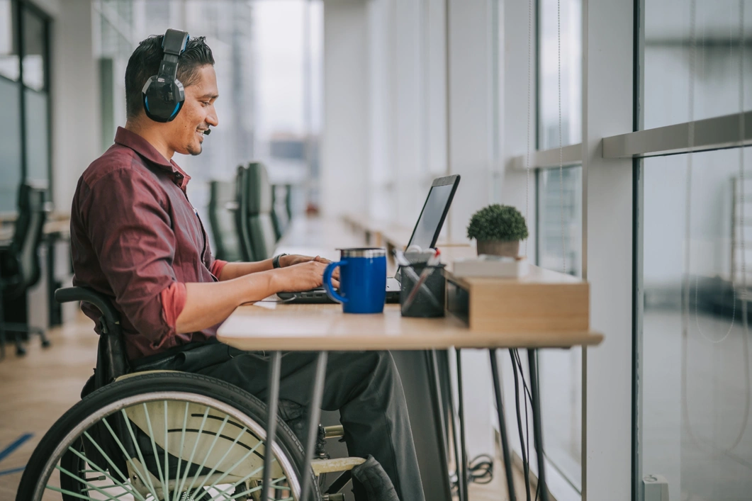 Worker with disability on wheelchair talking to the camera video calling video conference with his business partners