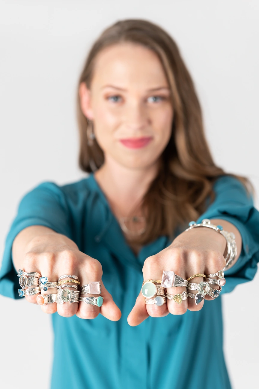 woman standing with both fists out wearing lots of rings
