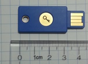 flash drive with lock on it above ruler measuring four inches