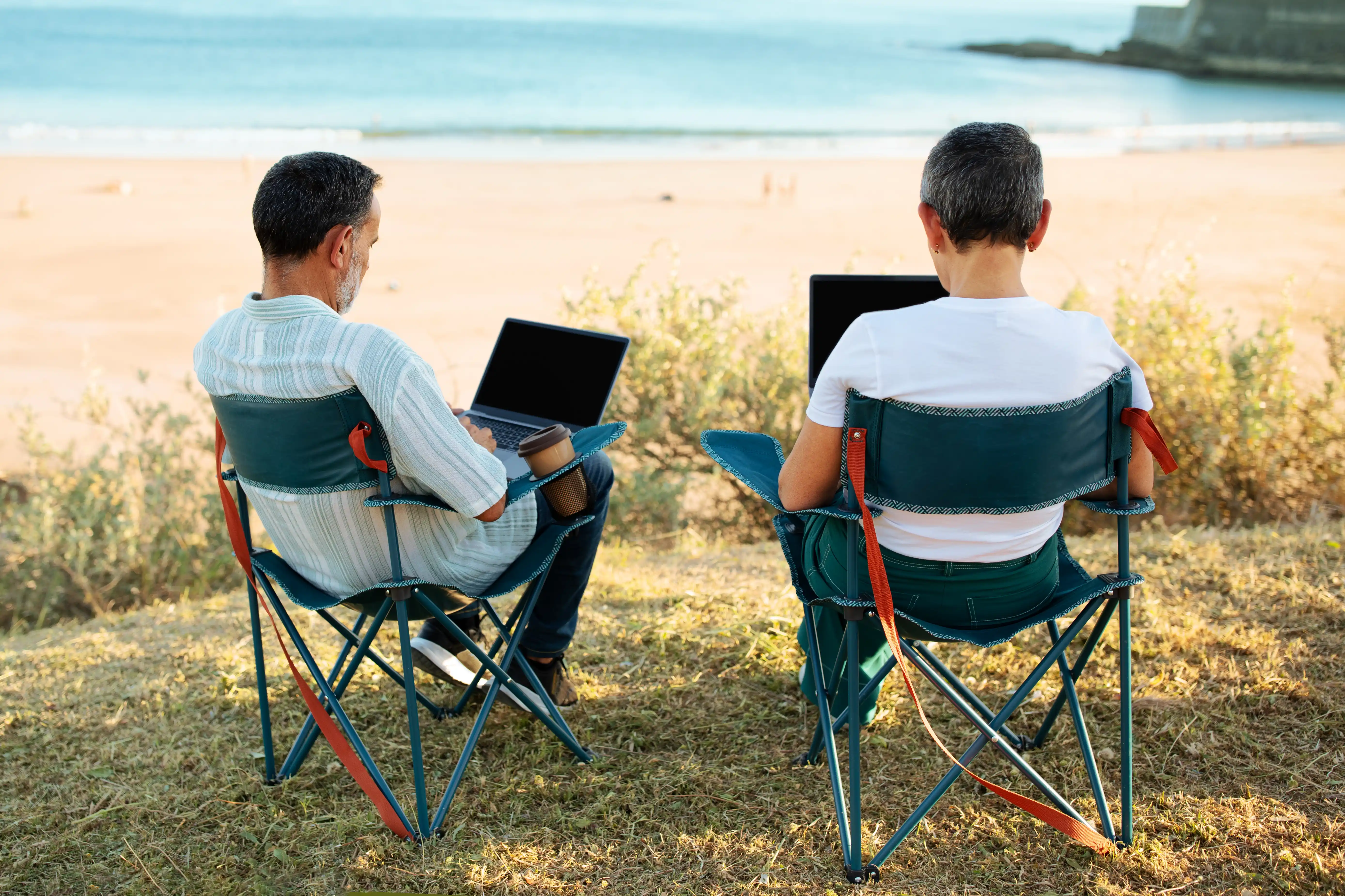 Remote professionals working on laptops outdoors