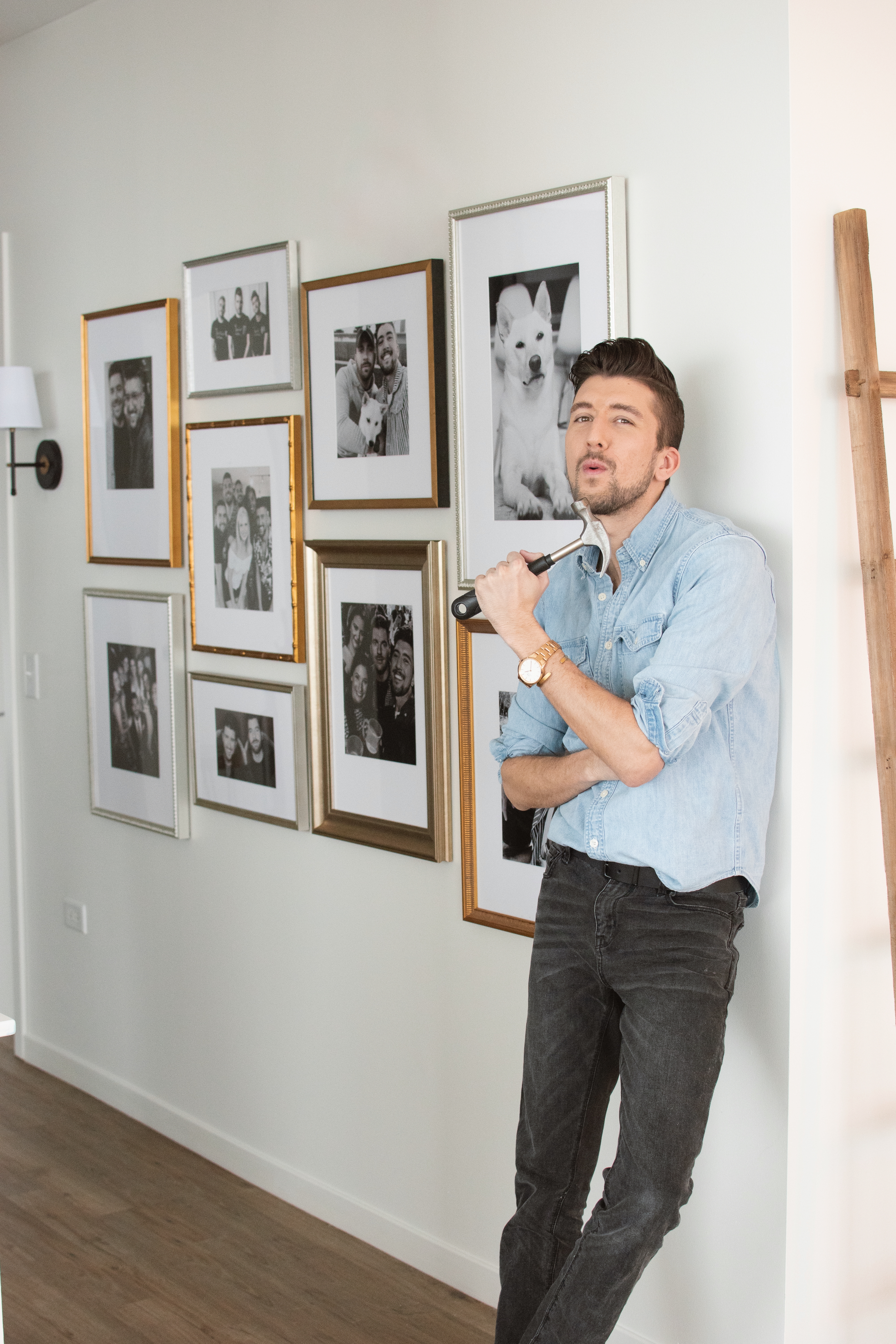man with hammer in front of gallery wall